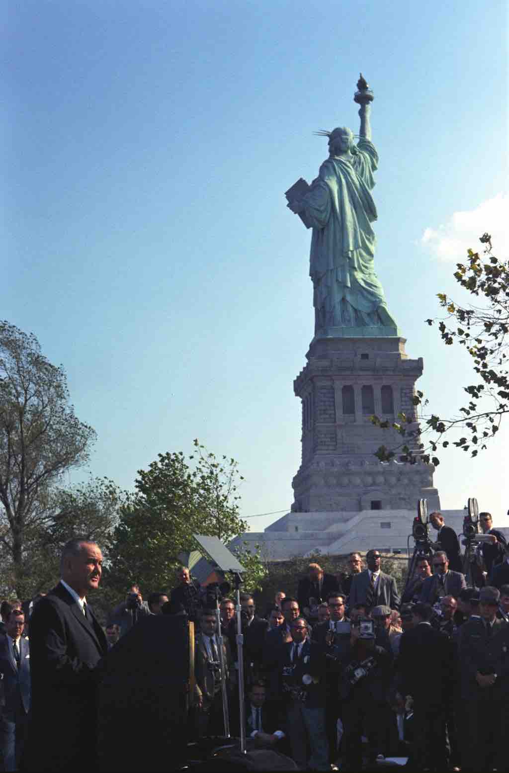 President Johnson signs the Immigration and Nationality Act at the foot of the Statue of Liberty