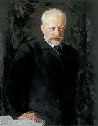 A middle-aged man with grey hair and a beard, wearing a dark suit and staring intently at the viewer