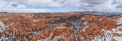 Landscape with red and pink rocks with some snow