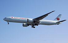 Aircraft landing approach. Side view of twin-engine jet in flight with flaps and landing gear extended.