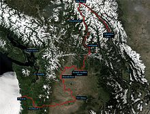 Modified satellite view of the Columbia River watershed showing the course of the river in red from Columbia Lake in British Columbia, Canada, to Astoria, Oregon, in the United States. The maps shows that the river, although flowing on average in a southwesterly direction from source to mouth, changes direction sharply from northwest to south at Big Bend in Canada, from south to west near Grand Coulee Dam in Washington, from west to south near Wenatchee, Washington, and from south to west near the Tri-Cities area in Washington.