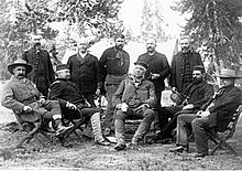 A group of men seated in a forest