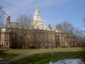 Four storey red brick building with a white clock tower.