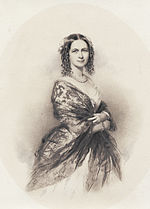  photograph of lady in dress and shawl, pearl necklace, body facing right, smiling face facing viewer